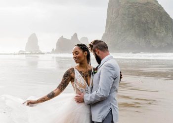 A wedding couple is holding each other in Cannon Beach in Oregon. One of the best elopement venues in Oregon.
